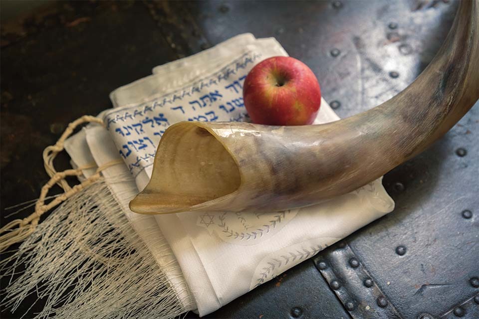 Shofar, apple, and ṭallit (prayer shawl)