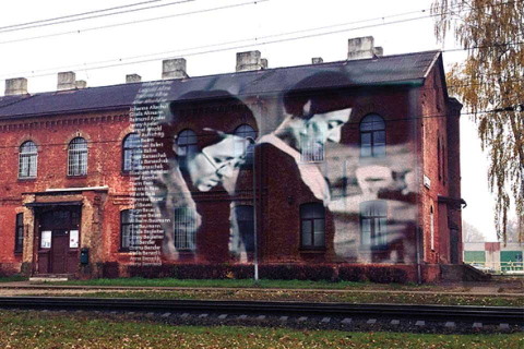 Digital illustration of iconic images connected to Jungfernhof projected onto the wall of the Šķirotava train station in Latvia. 