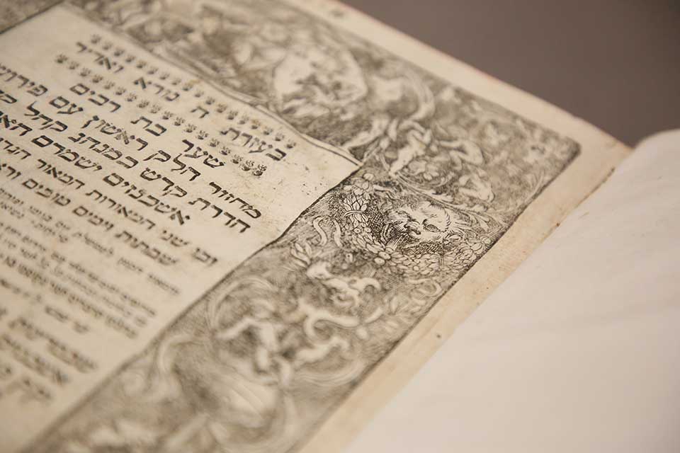 a close up view of the Hebrew text and line drawing of an animal encircled with a wreath.