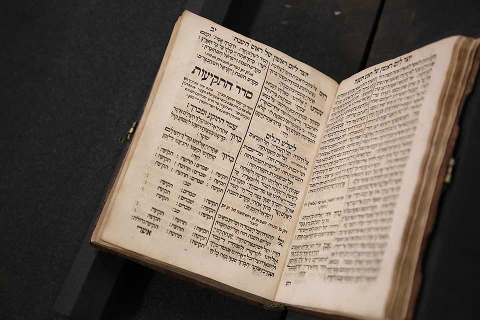 an old, open prayer book with Hebrew writing
