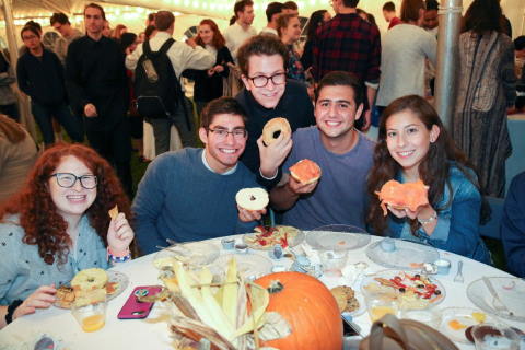 Students gathered around table eating