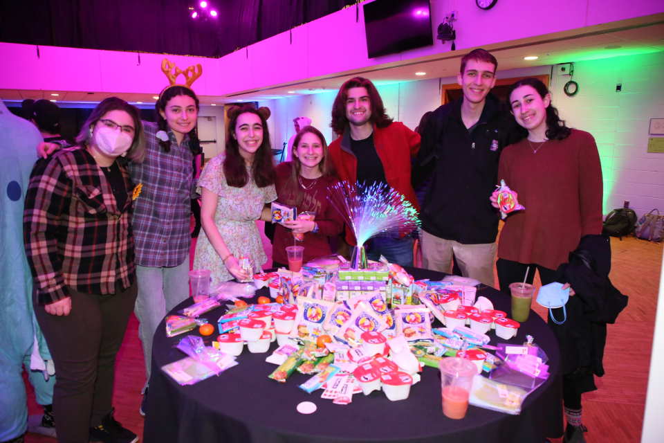 Students gathered around a table smiling