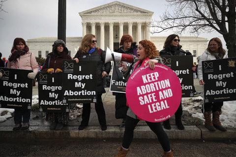 Protesters on both sides of abortion story holding signs