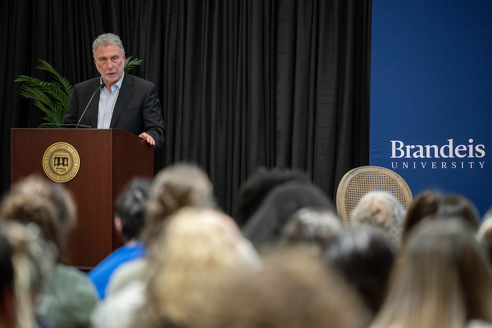 Marty Baron stands at a podium as an audience looks on.