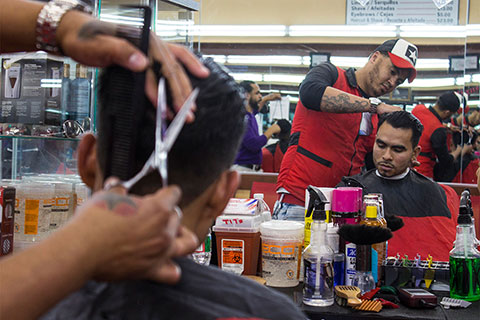 Barber cutting a man's hair in a salon.
