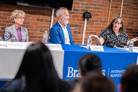 Speakers sit at a table at the Economics of Climate Change panel
