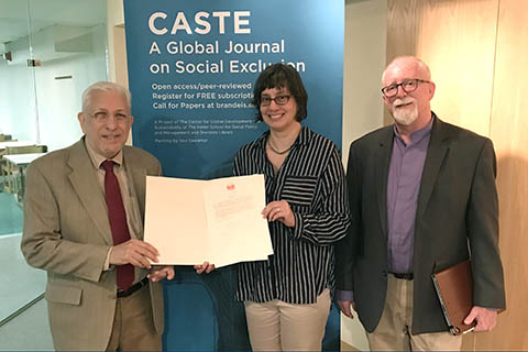 Brandeis University Professor Laurence Simon, left, presents the letter from the Dalai Lama to University Archivist Maggie McNeely and University Librarian Matthew Sheehy.