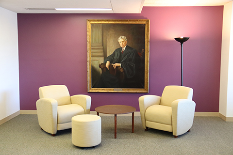 Louis Brandeis portrait between two armchairs and a small table