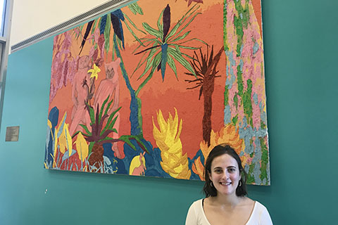 Woman standing in front of a colorful painting