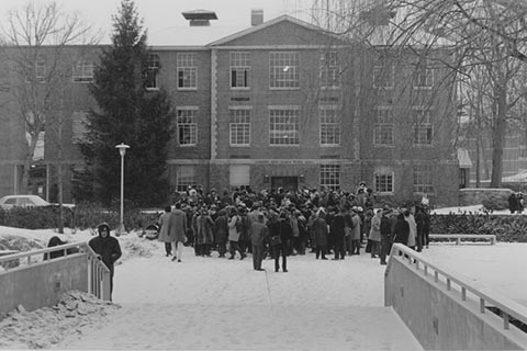 A crowd gathers in front of Ford Hall to protest.
