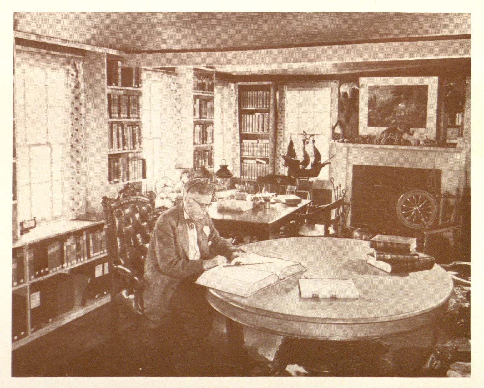 Photograph of McKew Parr reading at a table in his library