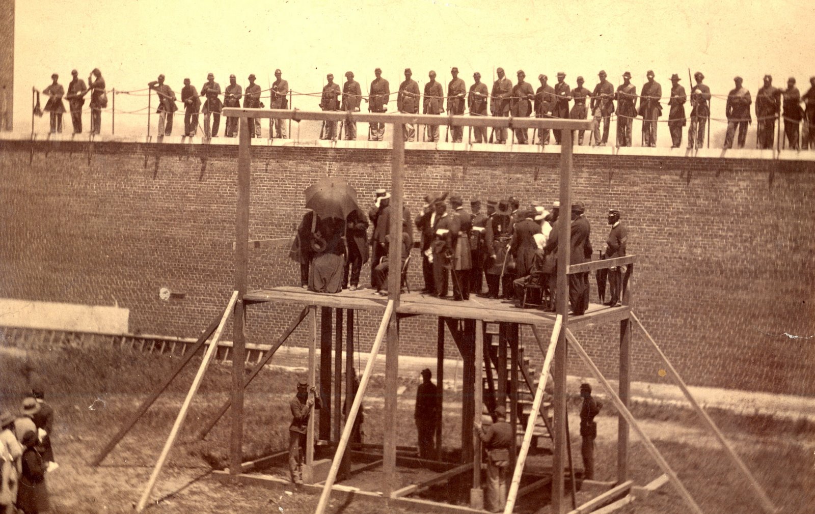 Photograph of four Lincoln assassination conspirators standing on a platform awaiting their public hanging in Washington D.C. Ft. McNair