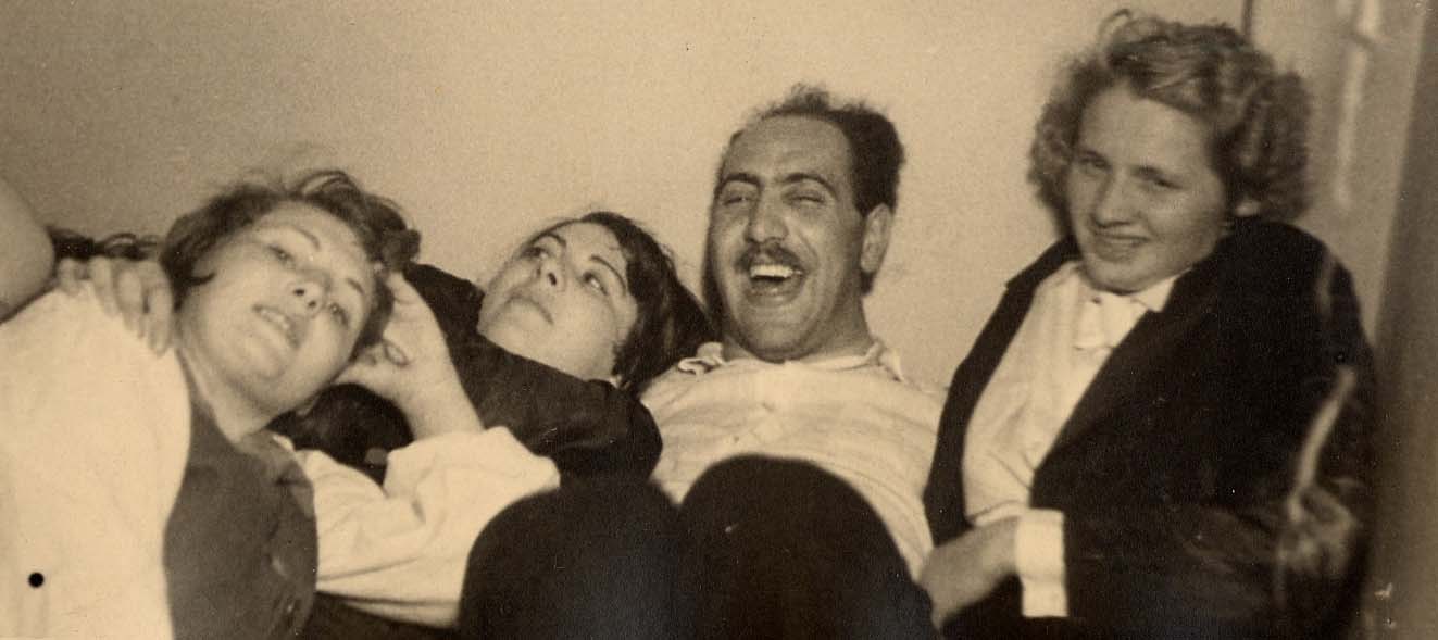 Photo of 3 women and one man smiling, lying down