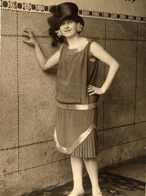 Woman with top hat and a 1920s dress.  "1927" is written in pen in the upper right corner of the photo.