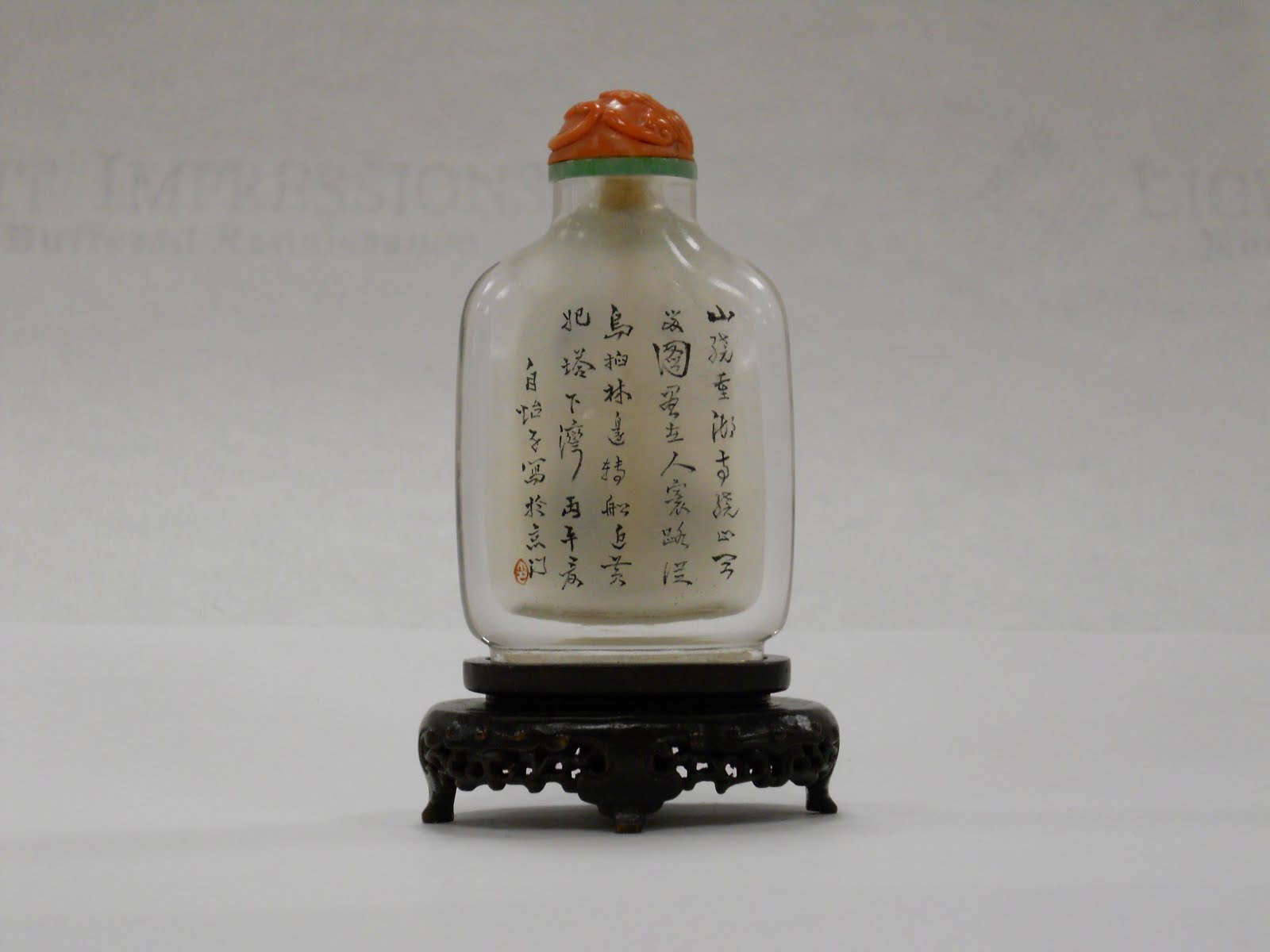 Reverse side of snuff bottle with man in round hat. This side has Chinese lettering.