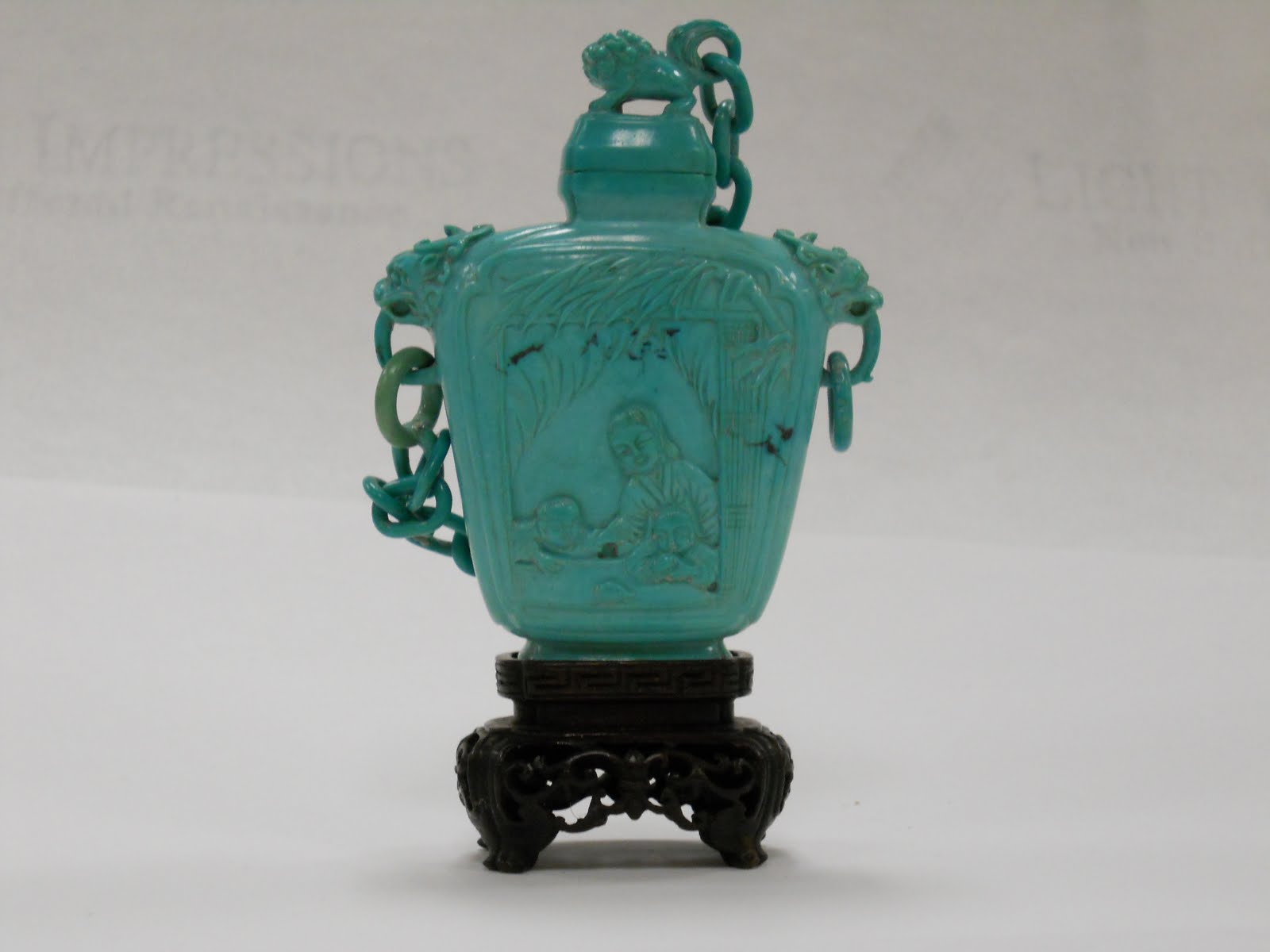 Carved turquoise snuff bottle with a chained cover
