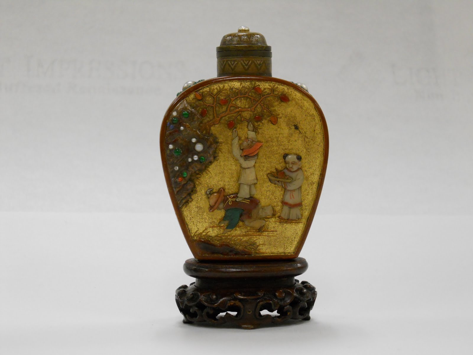 Rare gold lacquer and pietra dura bottle made with amber lacquer, with a tessellated gold ground depicting a scene of three small boys picking peaches.