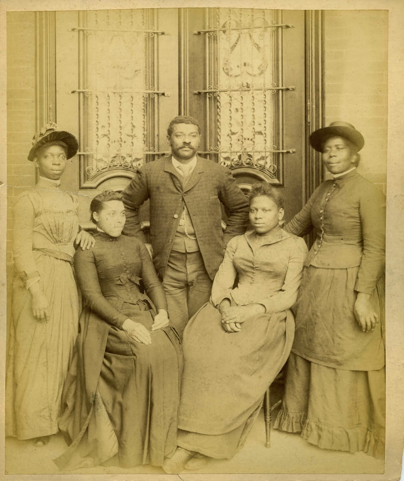 Formal portrait of four black women and one man, all dressed in fine clothing.