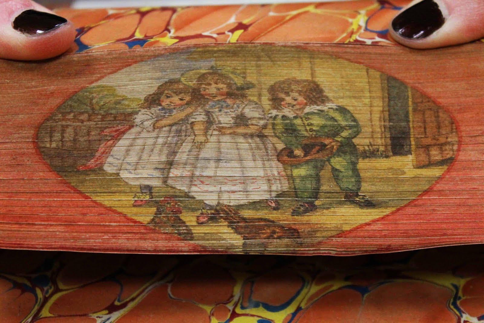 Colorful fore-edge painting of two girls and a young boy laughing at and possibly feeding two roosters