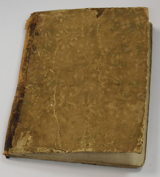 Old brown cover of manuscript copy of the Anaphora of Saint Cyril with faded floral design