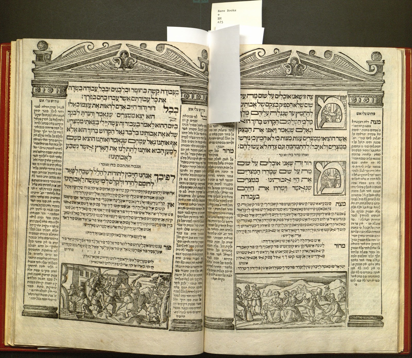 Haggadah open to show two pages of core Hebrew text flanked by commentary in Ladino. Woodcut illustration frames the text on each page as Classical-style buildings, with pediment and columns; Additional woodblock illustrations include historiated initials and scenes from the Haggadah.