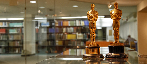 Two Oscars with the Brandeis Library's 2nd floor in background