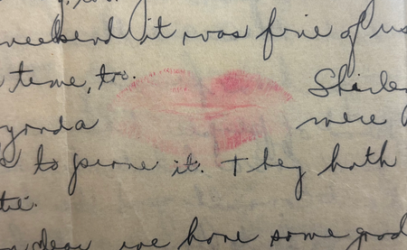 A lipstick kiss amongst handwritten script.