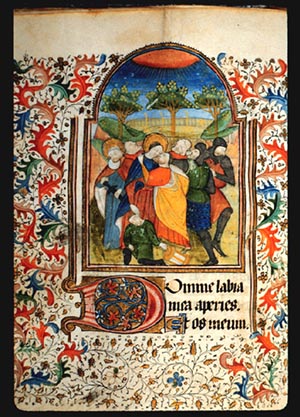 Painting on page 39v of The Kiss of Judas (Betrayal in Gethsemane). There is a group of 7 people in the foreground, and trees in the background with an orange sun up above with rays of light.   The margins around the painting are filled with a painted border of achantus scrolls in red and blue, and leaf and vine patterns. 