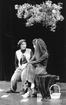 Women Performing "Women and Shakespeare" 1991. Two actors seated on stage facing each other one wearing men's attire; the other in  a long skirt.