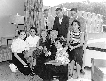 Sophie Tucker seated, in group picture with students who kneel beside her and stand behind her.