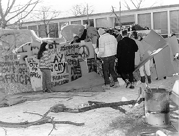 Shantytown built by Students in Reaction to Apartheid, made of cardboard with spray painted words and peace signs. February 3, 1986