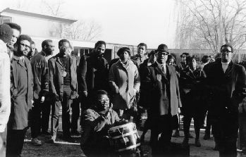 Black Student Occupation of Ford Hall January 8, 1969. One student in the center plays a drum.  A large crowd stands all around.