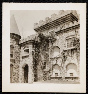 Closeup of the castle, with focus on architectural details of the turret and crenels along the roof.