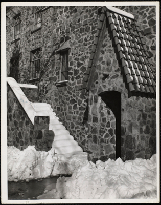 Castle in the snow. Closeup view of the steps and one of the entrances with a steep shingled roof.