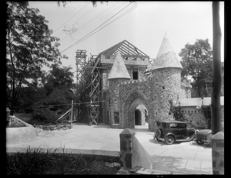 View of the castle with scaffolding, behind the wall and entryway.