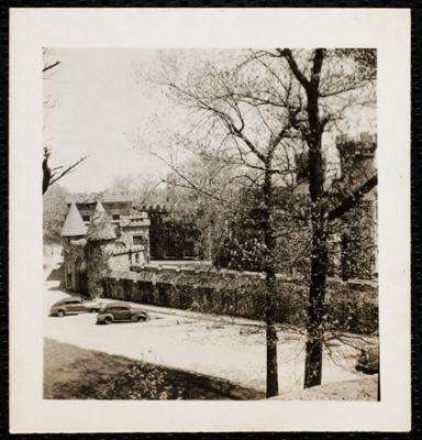 Aerial view of Castle with two cars parked out front.