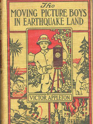 Cover of book "the Moving Picture Boys in Earthquake Land" by Victor Appleton.  There is an illustration in the center of a boy wearing a safari hat with a camera on a tripod. This picture overlaps 4 other pictures of a bear on its hind legs by a ree, wild animals, a sinkning ship and a building on fire with firemen on a ladder 