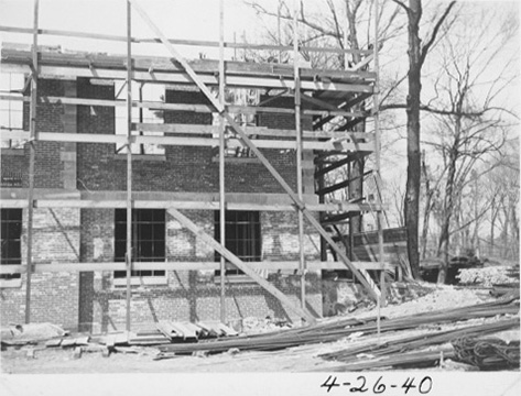 the second story is being added to the building behind scaffolding.