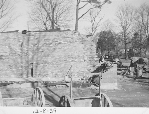 Bricklayers working on the walls in the distance. There are 2 carts in the foreground