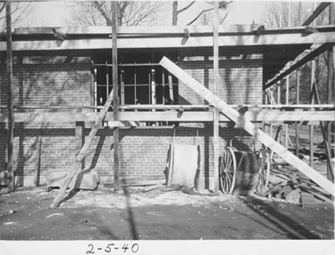 The exterior of the building under construction with scaffolding and wood beams.