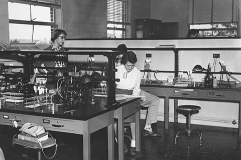 Four students working in a science lab in 1954.