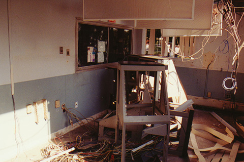 An empty room with telecommunications equipment that had been ripped out of the walls.
