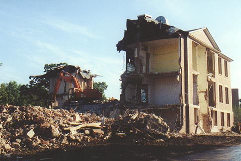  An excavatorsitting on the second floor of Ford Hall on top of the boulder that rests in the center of the first Floor. 