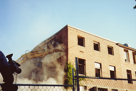 First in a sequence of an excavator tearning down a corner of Sydeman Hall