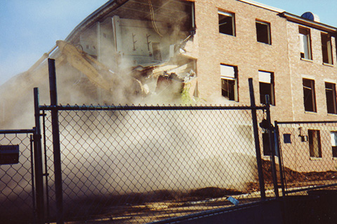 Third in a sequence of an excavator tearning down a corner of Sydeman Hall 