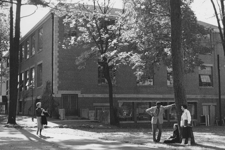 Ford Hall seen from the back, with students in small groups talking or walking