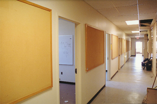 Hallway with open doors and empty bulletin boards, 2000