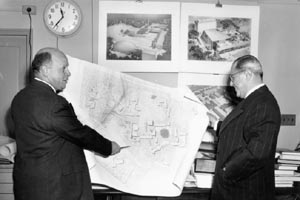 Two Brandeis Associates reviewing the first University Master Plan. On the left is Harold Goldberg, holding the blueprint and pointing with a pencil to one part of the plan.