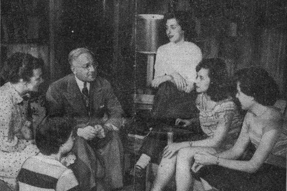 Photograph from News article in the NY Herald Tribune, featuring thi photograph of Dr. Sachar engaged in a chat with students and the residential director in a girls' dorm.