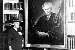 Mrs. Susan Brandeis Gilbert daughter of Justice Louis Brandeis posing in front of the portraint of her father she has just donated. 